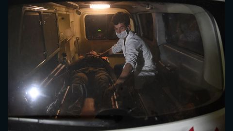 A responder assists an injured man in an ambulance in the aftermath of the university attack. 