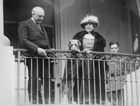 President Warren G. Harding, first lady Florence Harding and their Airedale terrier, Laddie Boy, watch from a balcony as the annual Easter Egg Roll takes place on the White House lawn, circa 1922. 