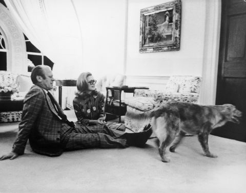 President Gerald Ford sits with his daughter, Susan, on the floor of the White House's Great Hall watching their golden retriever, Liberty, circa 1978.