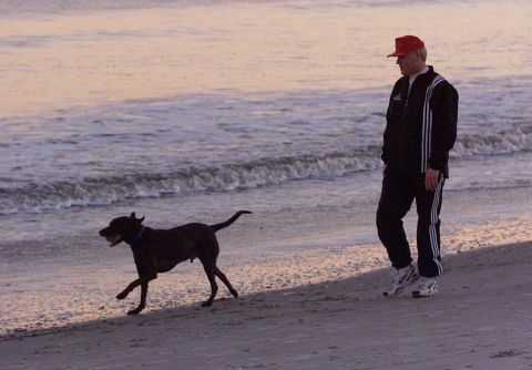 Clinton walks Buddy along the beach during sunset in Hilton Head, South Carolina, on December 30, 1992.