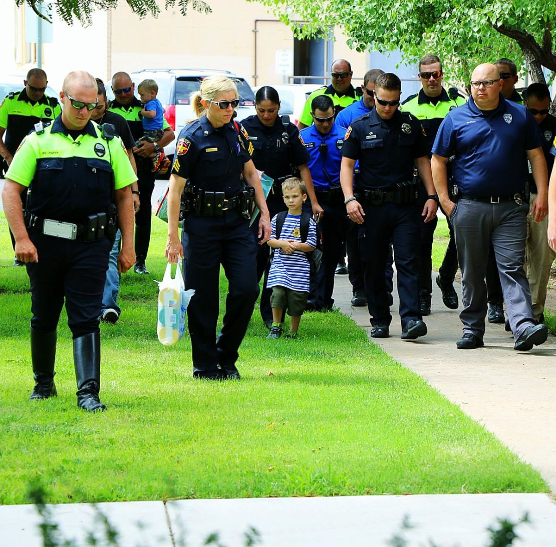 Jackson Scherlen walks with members of Amarillo police on his first day of school.