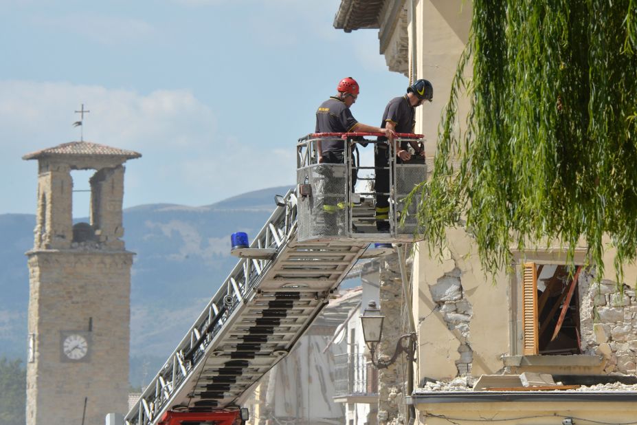 Firefighters inspect a damaged building from the elevated platform of a firetruck in Amatrice on August 26. Amatrice has been the hardest-hit town, with more than 200 killed there.
