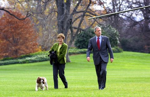 President George W. Bush and first lady Laura Bush walk with their dogs, Barney and Spot, on the South Lawn on December 2, 2001.