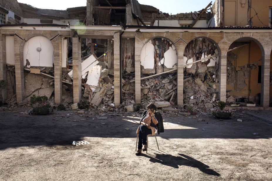 A woman rests in the courtyard of a convent in Amatrice on August 26.