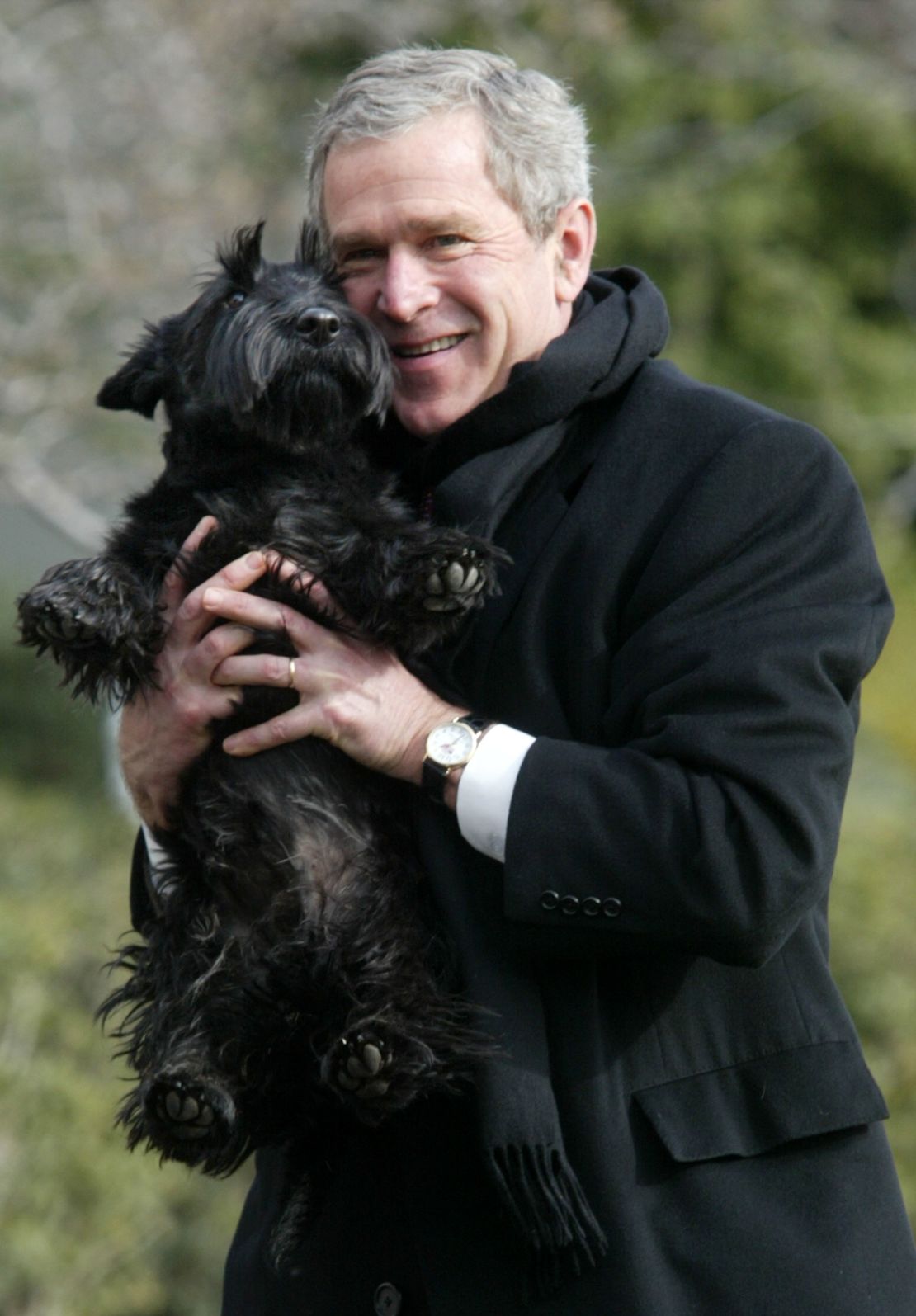 Bush holds up his dog Barney upon his arrival at the South Lawn of the White House on February 3, 2002.