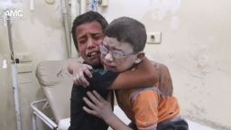 A harrowing video shows two boys crying and wrapping their arms around each other after a barrel bomb killed at least 13 people in Aleppo.