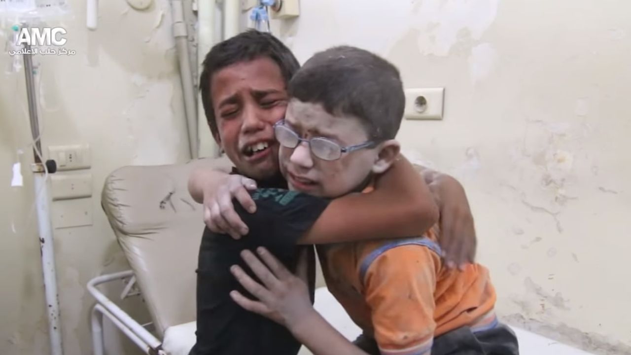 A harrowing video shows two boys crying and wrapping their arms around each other after a barrel bomb killed at least 13 people in Aleppo.