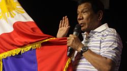 This photo taken on April 19, 2016 shows Rodrigo Duterte, front-runner presidential candidate for the May 9 elections, swearing in front of a national flag and supporters (not pictured) during a campaign sortie in Iloilo City, central Philippines.  
Trash-talking Philippine presidential favourite Dutere has warned he is prepared to cut diplomatic ties with the United States and Australia after their ambassadors criticised his joke about the jailhouse rape of a missionary. / AFP / STR        (Photo credit should read STR/AFP/Getty Images)