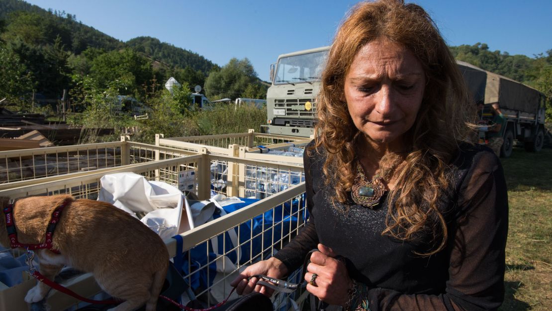 AnnaMaria tends to her cat near a staging area for the camp's emergency supplies. In the immediate aftermath of the quake, she and her family were trapped in their holiday home.