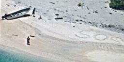 Two stranded mariners were rescued after a US Navy aircraft crew spotted SOS etched into the sand while flying over a deserted beach in Micronesia.