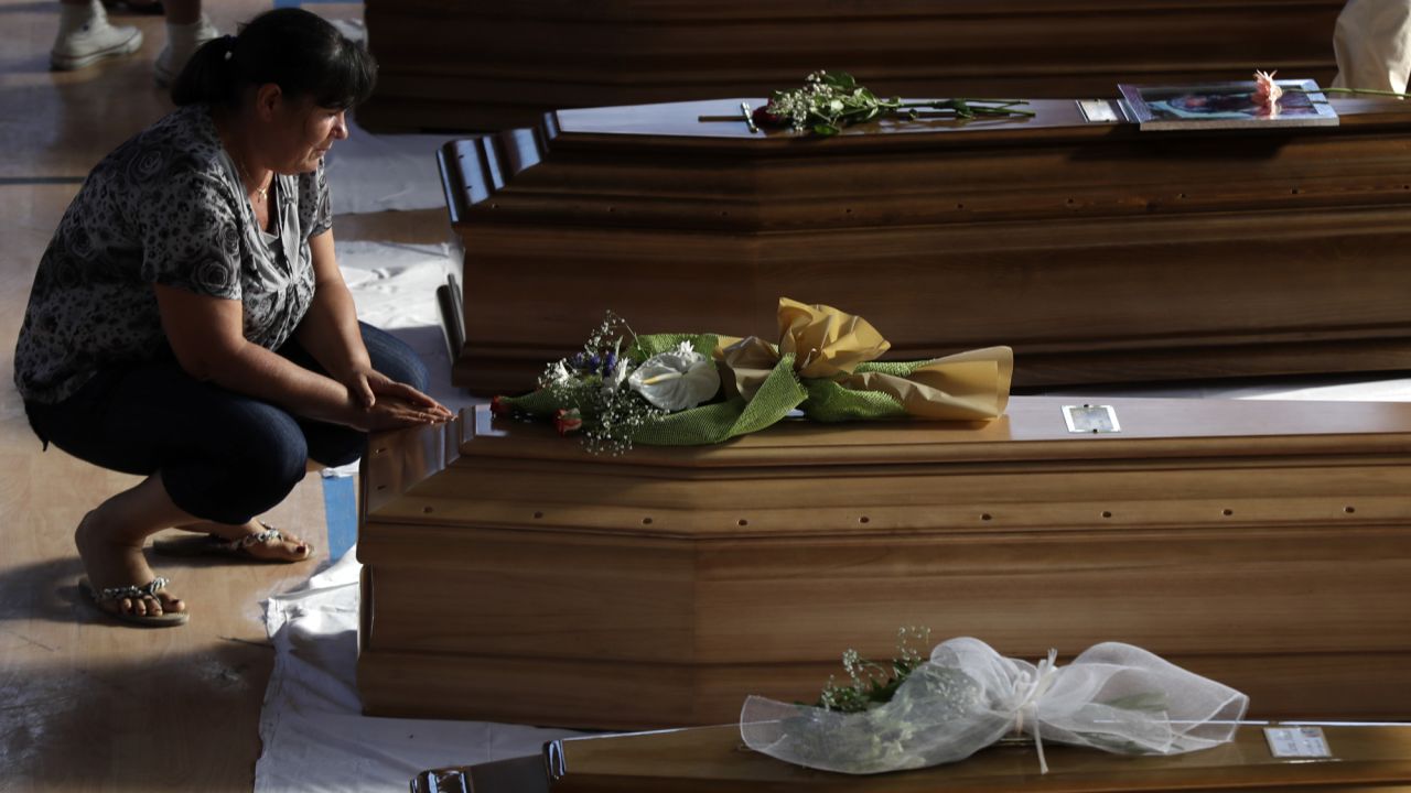 A woman touches a coffin of one of the victims during the funeral. 