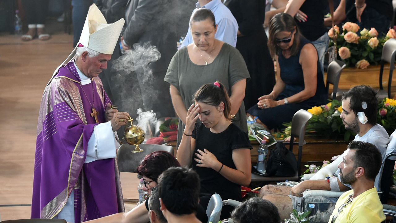 A priest conducts services during the funeral. 