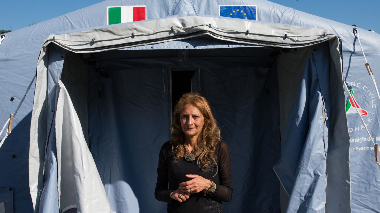 AnnaMaria Volpetti, 52, stands at the entrance of the tent where she and her family have sought refuge after their ancestral holiday home was ruined in Accumoli.