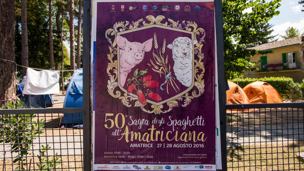 A poster for the 50th anniversary of Amatrice's famous pasta festival, set to take place the weekend following the earthquake, remains on the perimeter of a park now occupied by emergency response volunteers.