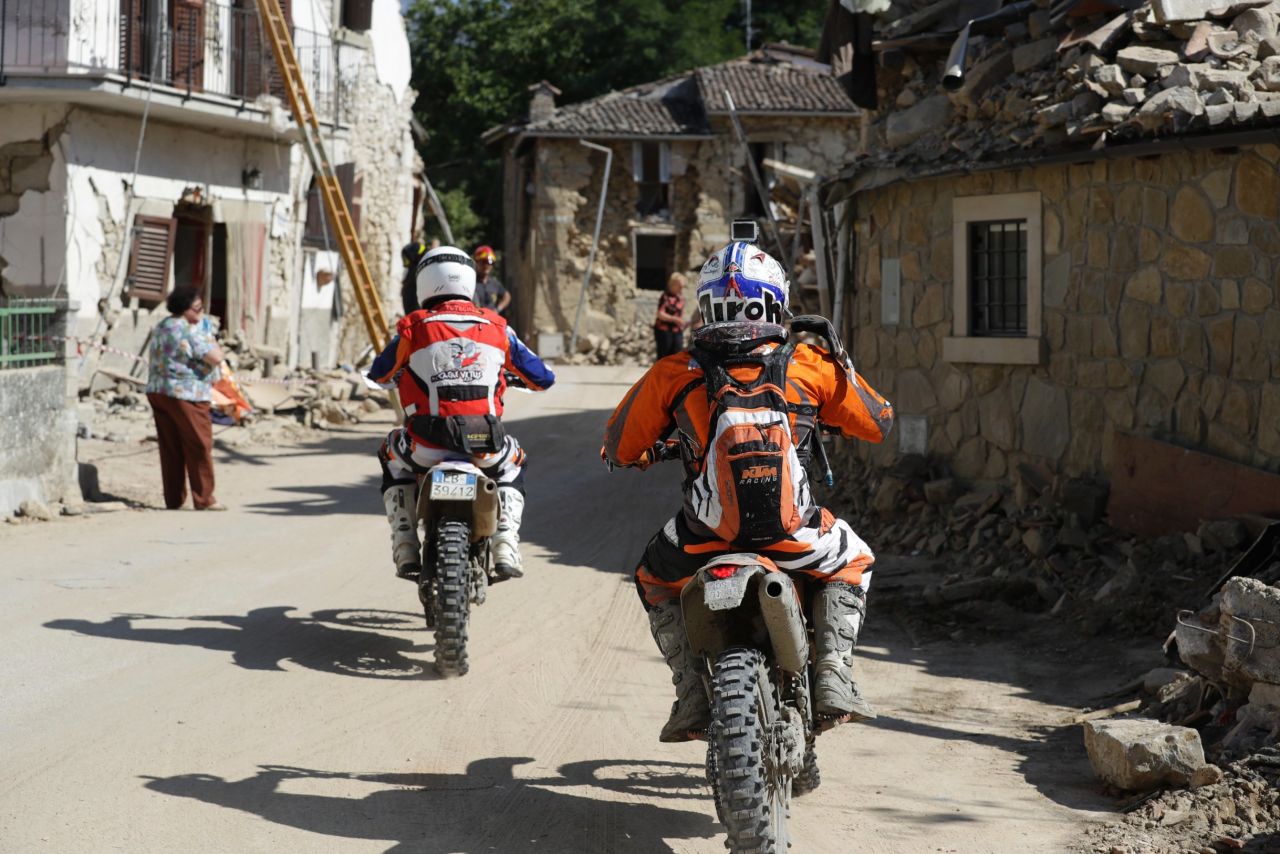 Volunteers on motorbikes drive through the town of Villa San Lorenzo a Flaviano, Italy, on August 28 as they bring supplies to smaller villages.