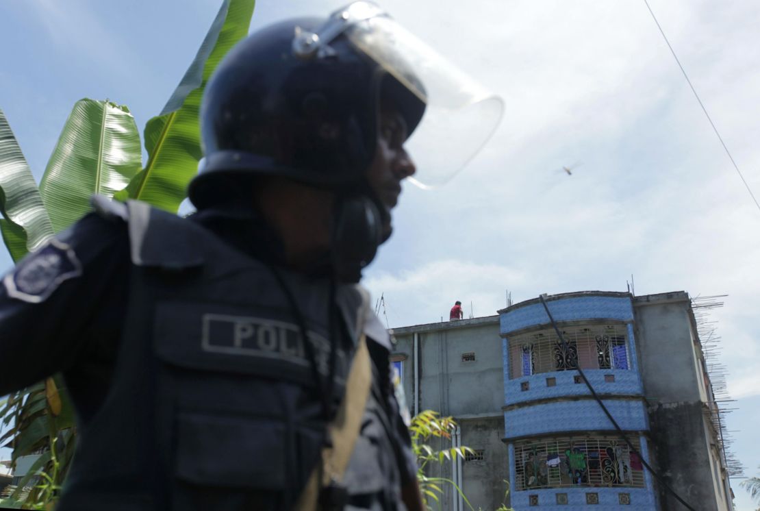 Bangladesh police stand guard near the building that was raided. 