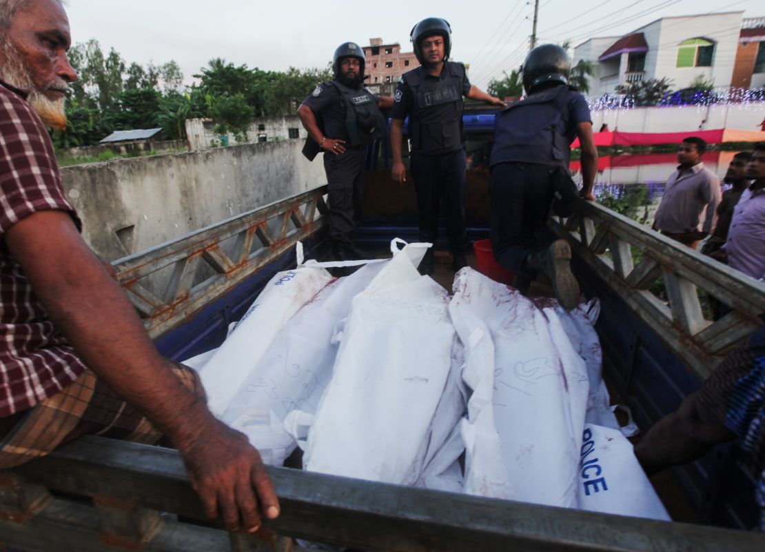 Bangladesh policemen transport the bodies of suspected militants involved with the Dhaka cafe attack following an operation to storm a militant hideout in Narayanganj, south of Dhaka on August 27, 2016.
