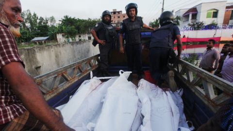 Bangladesh policemen transport the bodies of suspected militants involved with the Dhaka cafe attack following an operation to storm a militant hideout in Narayanganj, south of Dhaka on August 27, 2016.