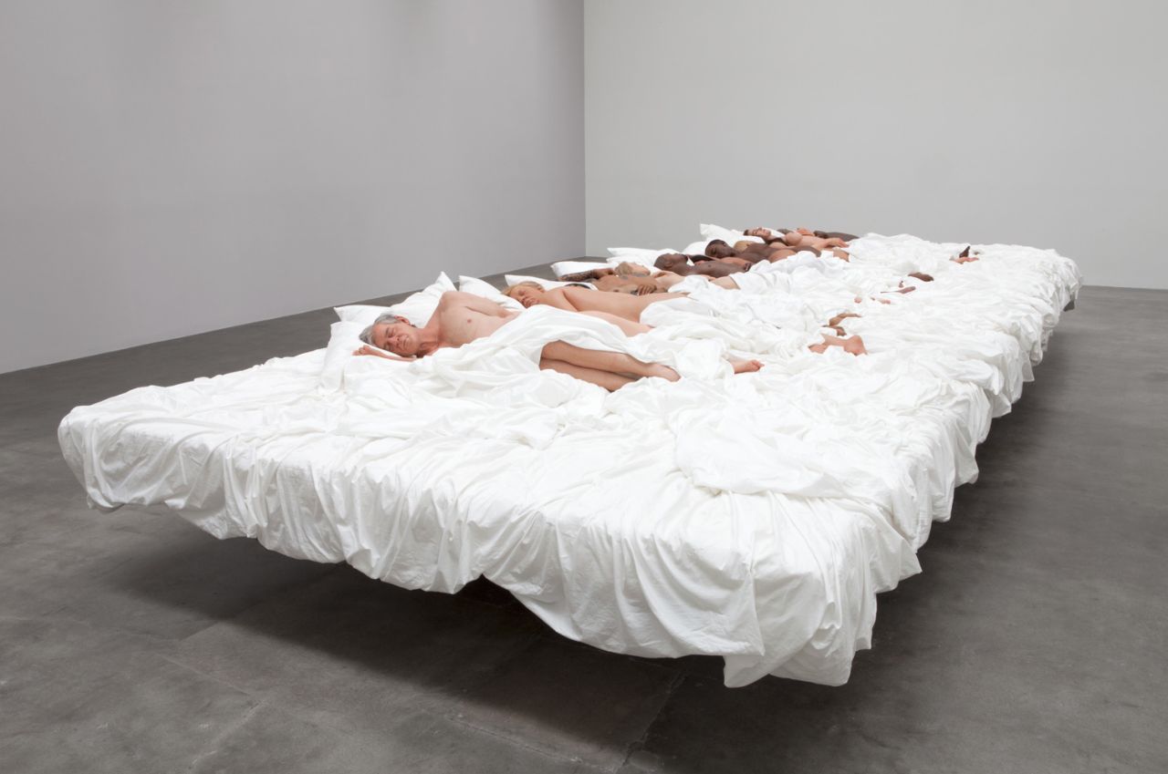 The video featured a large bed with lifelike sculptures that depict major cultural icons. 
