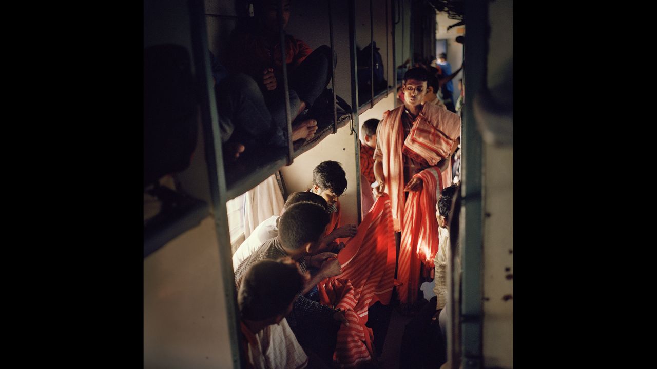 A vendor shows textiles to passengers on India's longest train, the Vivek Express.
