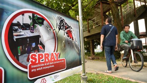 Residents are seen walking past a public service announcement banner against the spread of Aedes mosquitoes, a carrier for the Zika virus, at a residential block at Aljunied Crescent neighbourhood in Singapore on August 29, 2016.