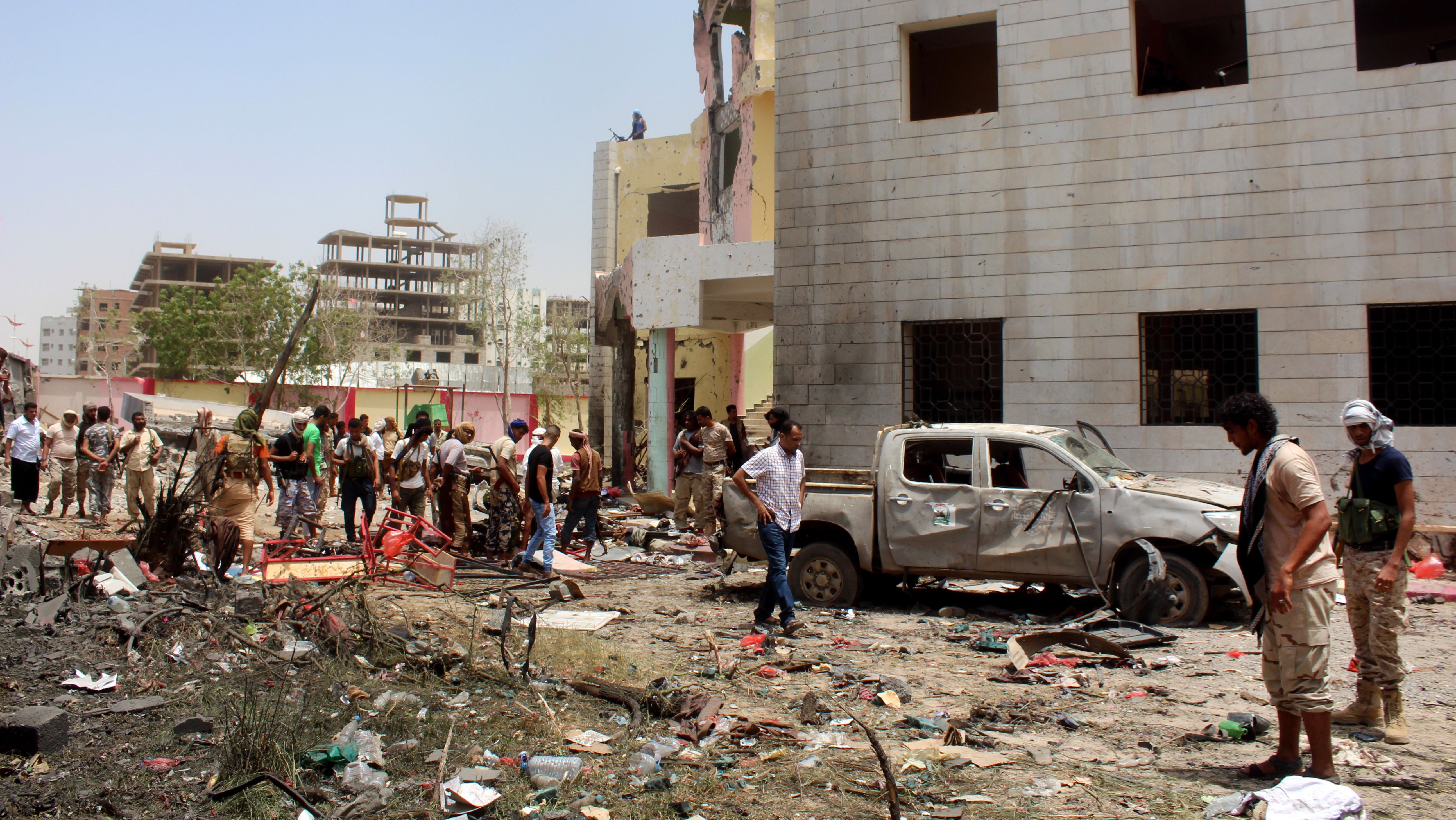 Fighters loyal to the government at the site of a suicide car bombing in Aden.