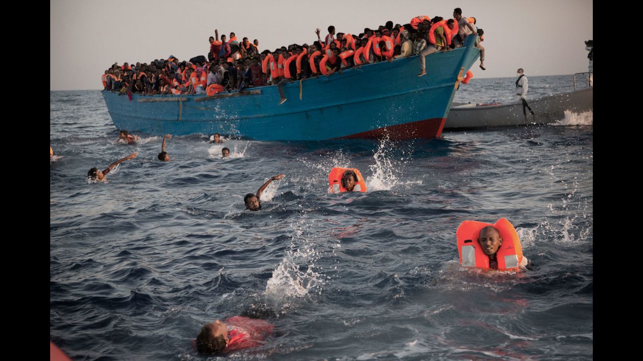 Migrants, most of them from Eritrea, jump into the Mediterranean from a crowded wooden boat during a rescue operation about 13 miles north of Sabratha, Libya, in August 2016.