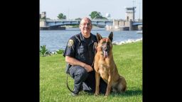 Officer Fred Laitinen kneels beside his canine partner "Cops". Courtesy Eric Jaeger