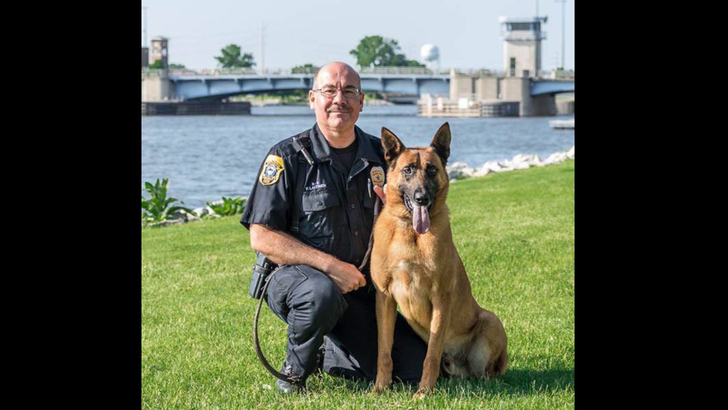 Officer Fred Laitinen kneels beside his canine partner "Cops".