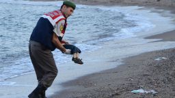 GRAPHIC CONTENT
A Turkish police officer carries a migrant child's dead body (Aylan Shenu) off the shores in Bodrum, southern Turkey, on September 2, 2015 after a boat carrying refugees sank while reaching the Greek island of Kos. Thousands of refugees and migrants arrived in Athens on September 2, as Greek ministers held talks on the crisis, with Europe struggling to cope with the huge influx fleeing war and repression in the Middle East and Africa. / AFP / DOGAN NEWS AGENCY / Nilufer Demir        (Photo credit should read NILUFER DEMIR/AFP/Getty Images)
