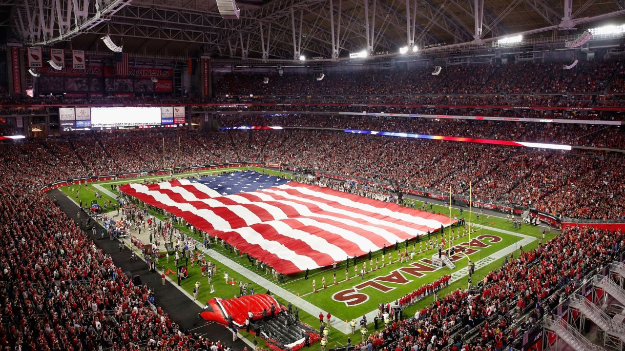 An American flag covers the field during the National Anthem before the NFL game between the Cincinnati Bengals and the Arizona Cardinals  on November 22, 2015.