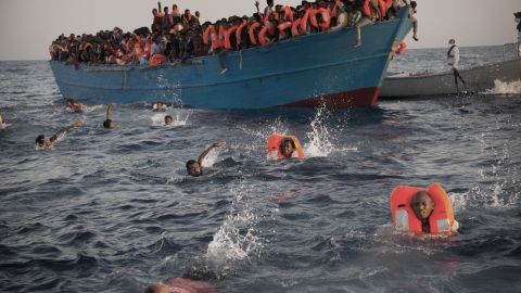 Migrants, most of them from Eritrea, jump into the water from a crowded wooden boat as they are helped by members of an NGO during a rescue operation at the Mediterranean sea, about 13 miles north of Sabratha, Libya.