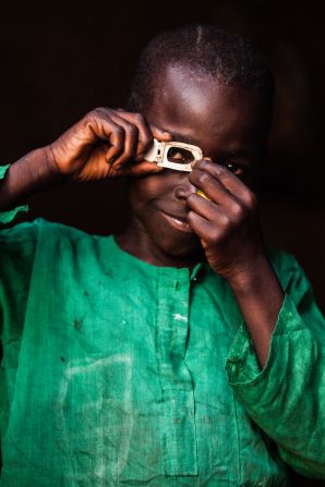 Mustafa (photographer) Central African Republic. Mustafa poses dressed up as how he sees himself in the future, as a photographer, Central African Republic