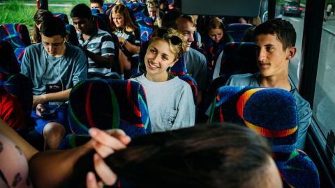 Campers and counselors ride a bus headed for Outward Bound, where they will participate in trust-building exercises.