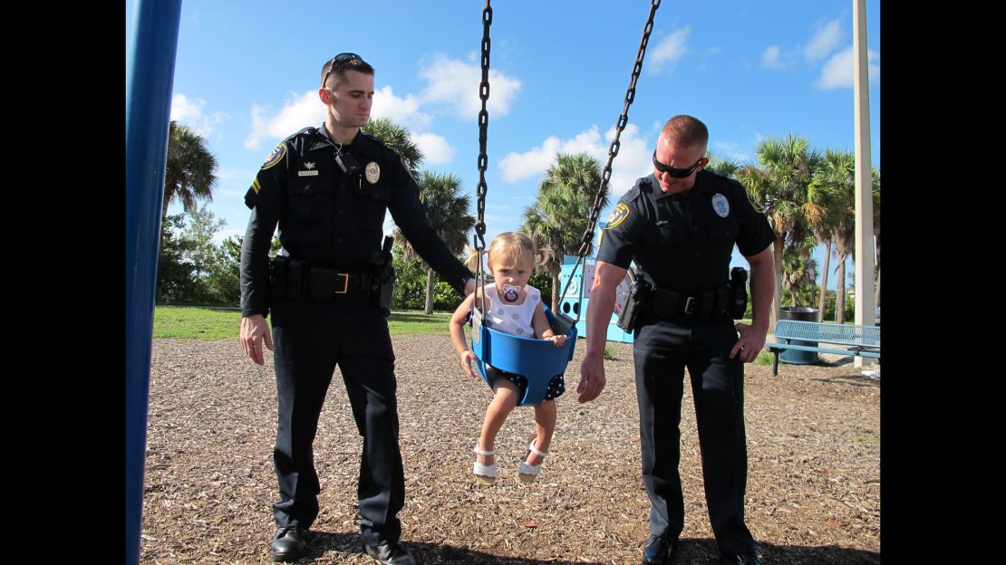 The officers who helped save Kennedy's life reunite with her at the swingset. 