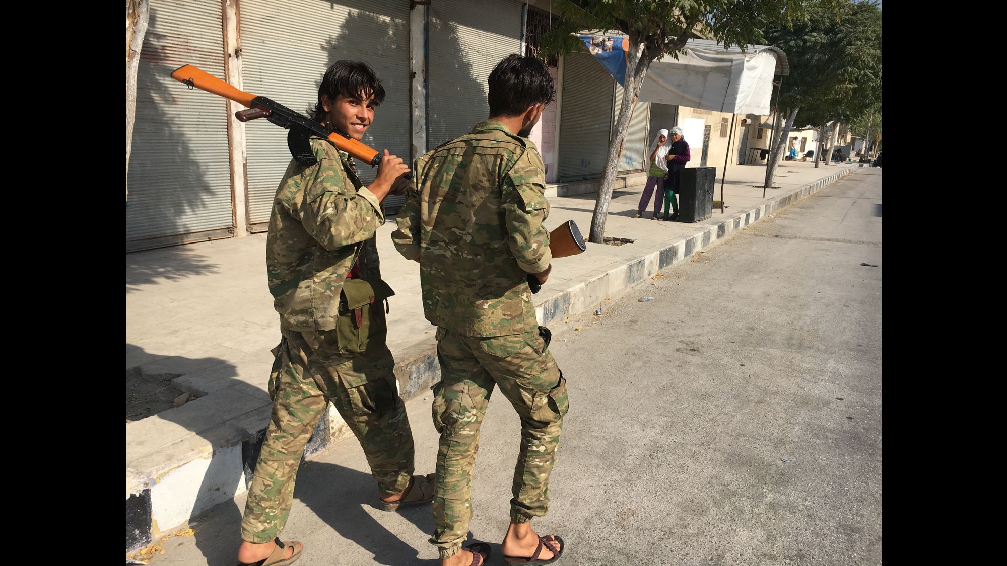 Two Free Syrian Army soldiers stroll down the main street of Jarablus after the city was liberated from ISIS.