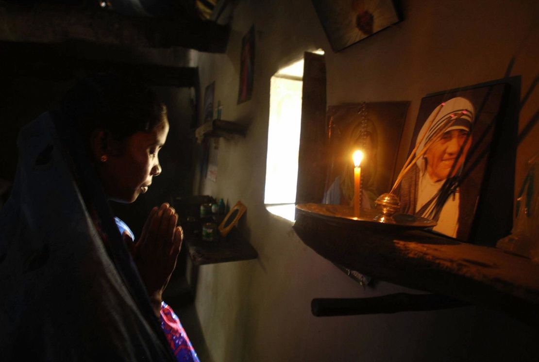 Monica Besra prays in front of a portrait of Mother Teresa in 2003.