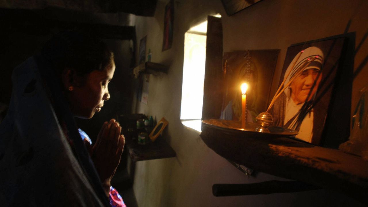 Monica Besra prays in front of a portrait of Mother Teresa in 2003.