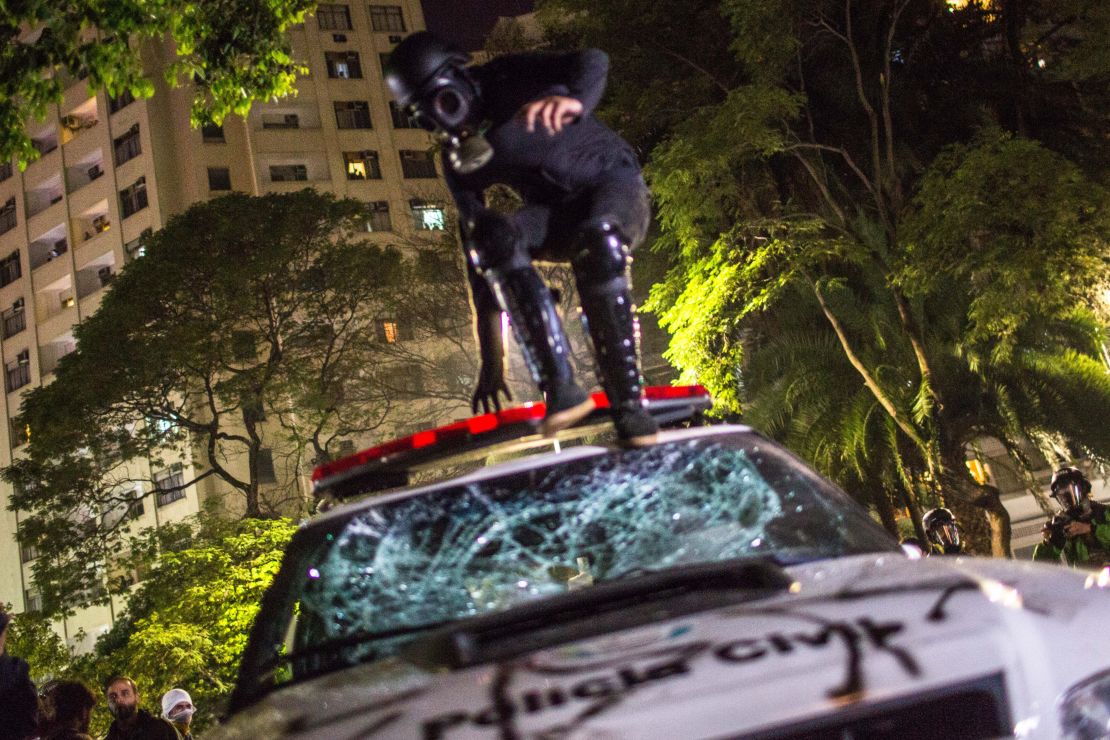 A protester jumps on a police vehicle during a march against the Senate vote Wednesday in Sao Paulo. 