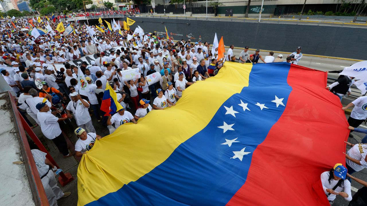 Opposition protesters unfurl a Venezuelan flag at a protest in Caracas.