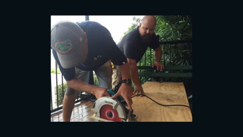 Joshua Wolfhagen, left, and Lake Smith cut a board for a window at The Consulate hotel in Apalachicola.