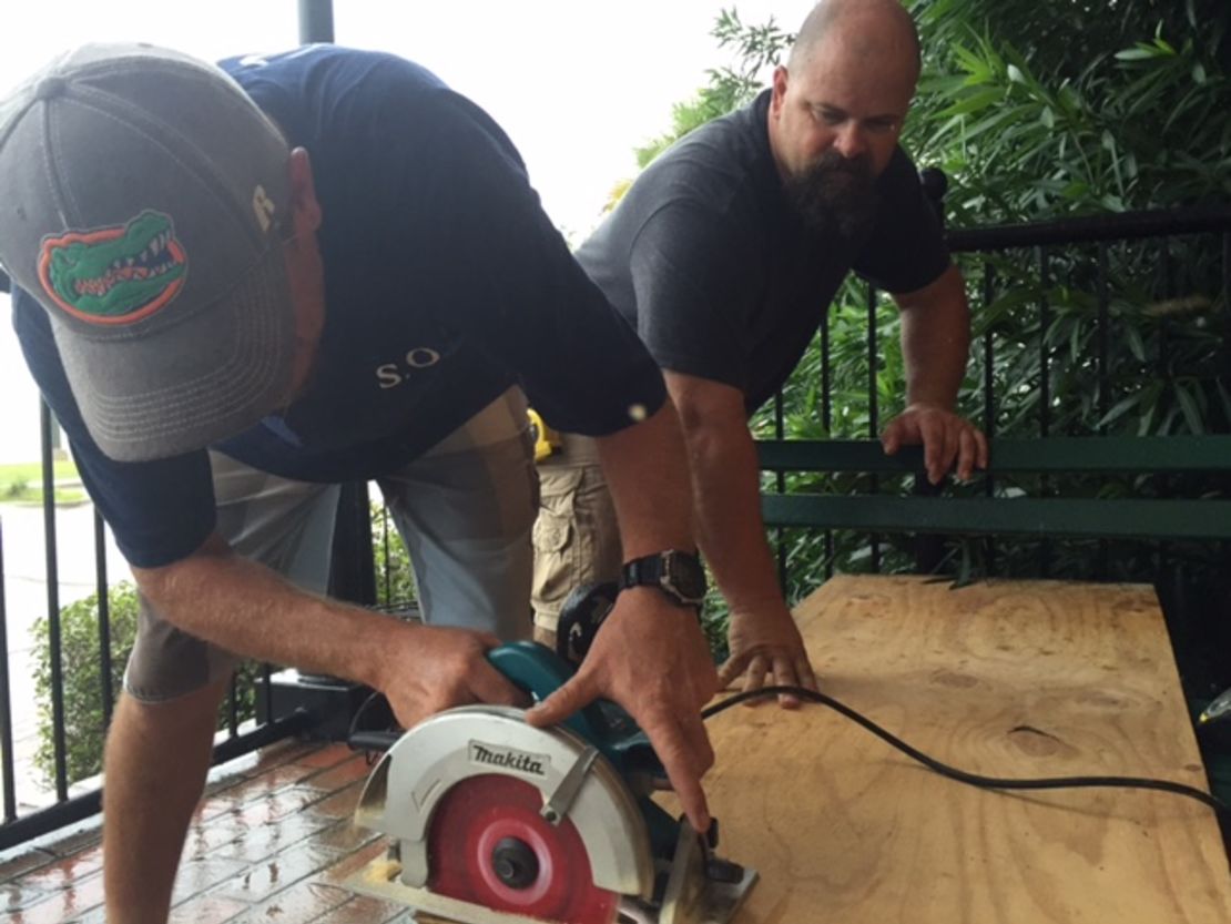 Joshua Wolfhagen, left, and Lake Smith cut a board for a window at The Consulate hotel in Apalachicola.