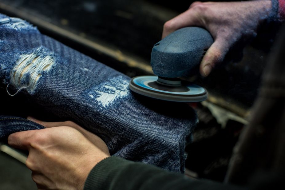 As other denim factories around the world shift towards a mass-production model, mills in Japan still offer quality fabric, some of which are treated by hand. Here, an employee at an Okayama mill distresses denim by hand. 