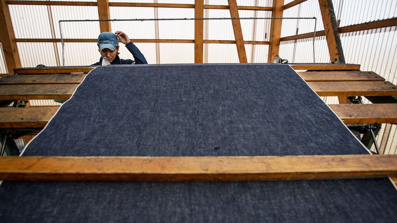 A man works a weaving machine at the Momotaro Jeans factory in Kojima district, Okayama. 