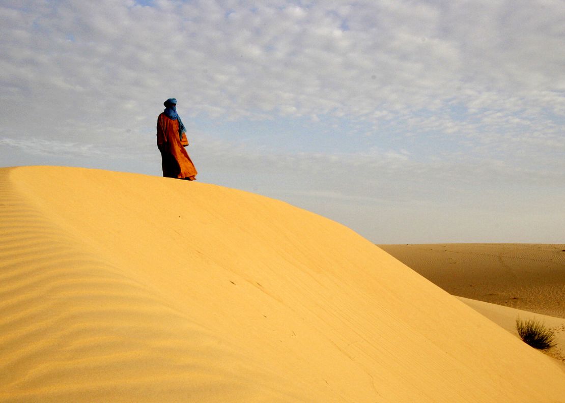 A lone Tuareg man standing on a dune in the desert near Timbuktu, northern Mali, 2005. Jubber visited the ancient city in the aftermath of the 2012 occupation and heard stories from residents who chose to remain.
