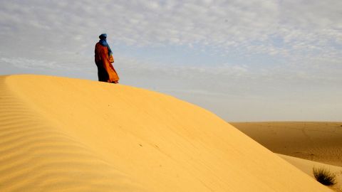 A lone Tuareg man standing on a dune in the desert near Timbuktu, northern Mali, 2005. Jubber visited the ancient city in the aftermath of the 2012 occupation and heard stories from residents who chose to remain.