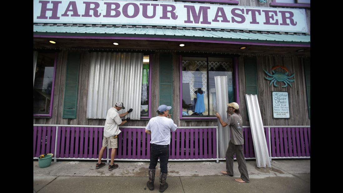 Workers in Cedar Key install storm shutters on a storefront as they prepare for Hermine on September 1.  