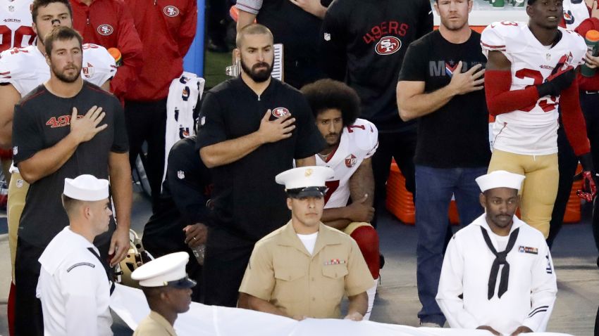 San Francisco 49ers quarterback Colin Kaepernick, middle, sits during the National Anthem before an NFL preseason football game against the San Diego Chargers, Thursday, September 1 in San Diego.