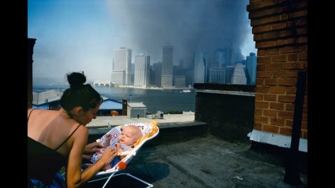 A mother gently tends to her baby on a Brooklyn rooftop as smoke envelops lower Manhattan. "There's some sense that, 'Well, this is the world he is coming into,'" Alex Webb says.