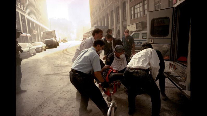 Paramedics lift a victim onto an ambulance for transport to a hospital. (Gilles Peress)